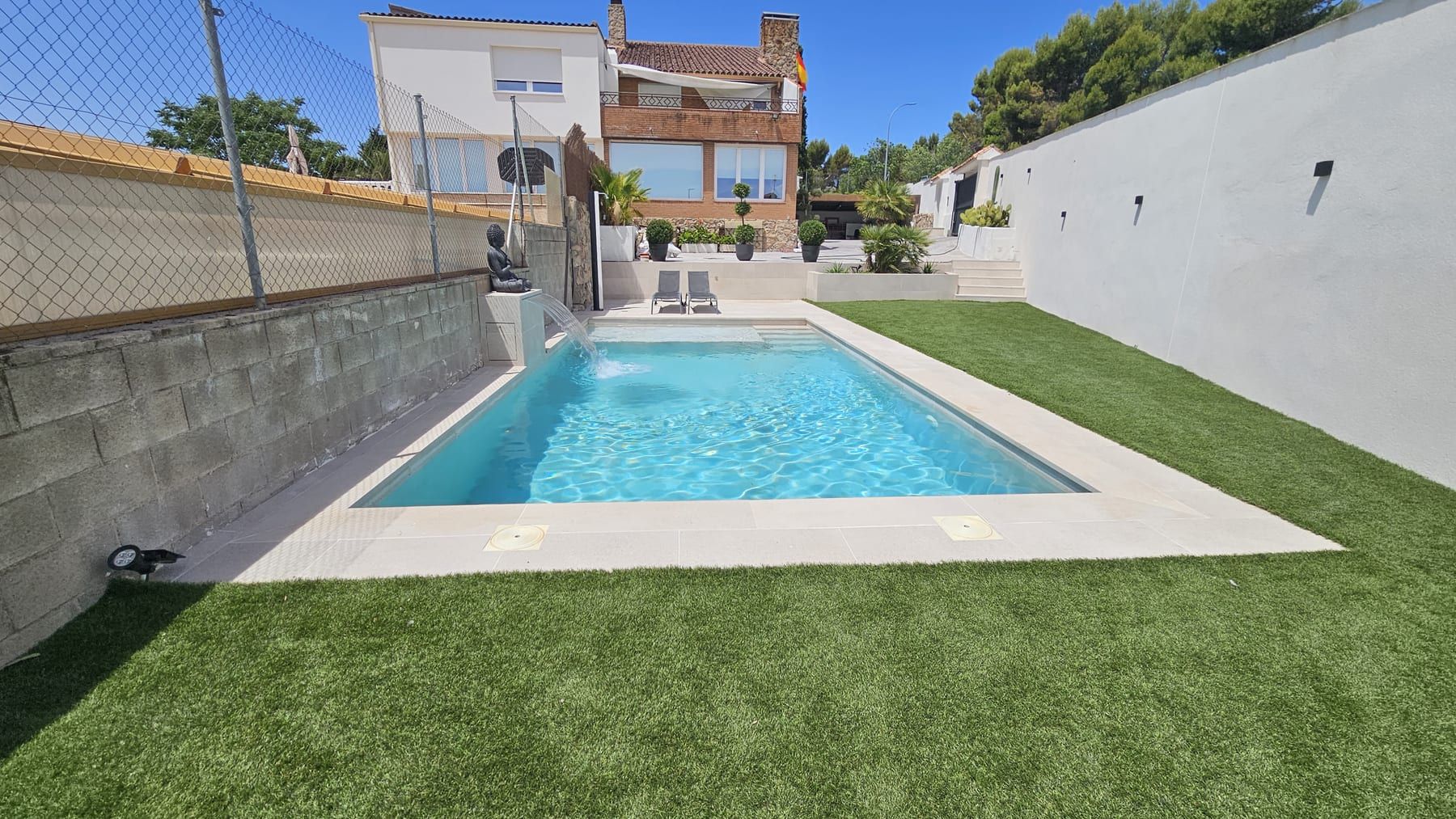 Piscina alargada con chorro y escalera de obra, vista 2