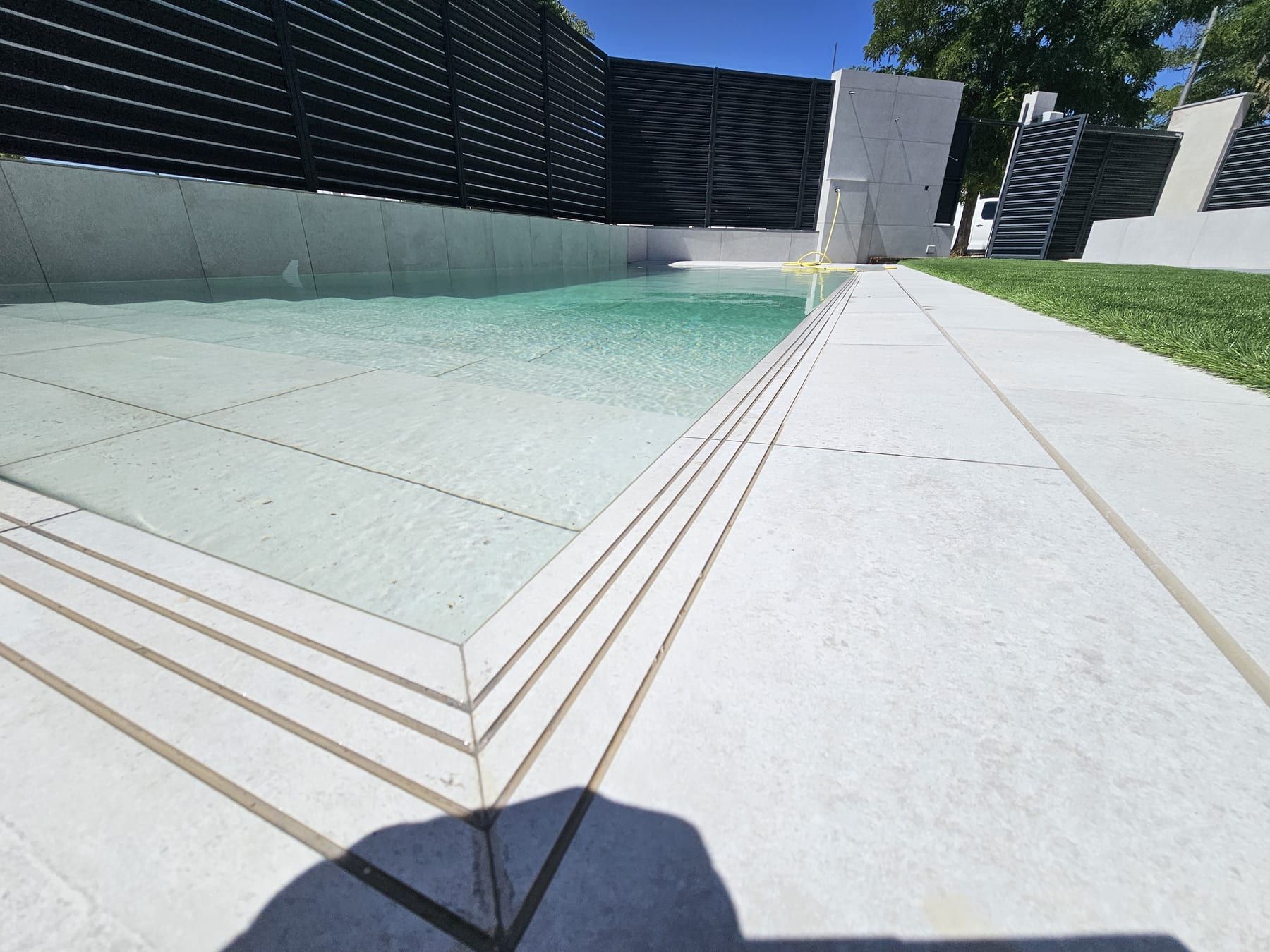 Piscina alargada con escalera de obra de ancho completo, detalle de la escalera