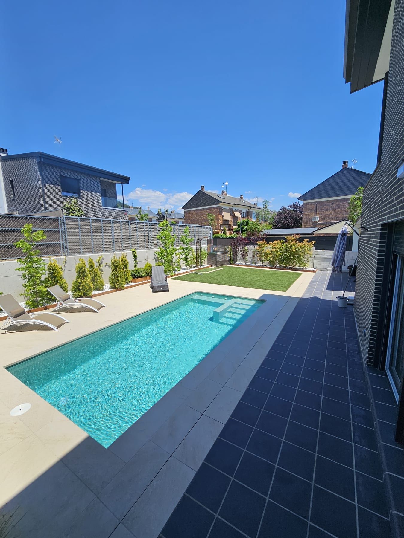 Piscina alargada junto a la vivienda