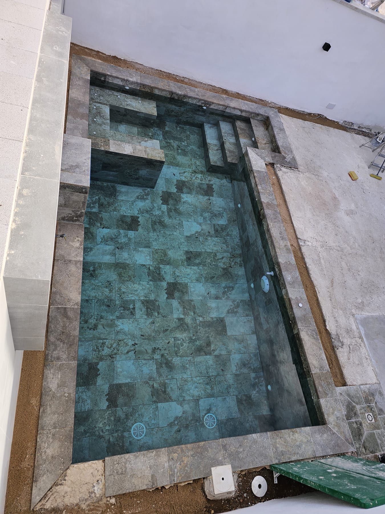Piscina con banco sumergido y chorros, durante la obra, antes del llenado