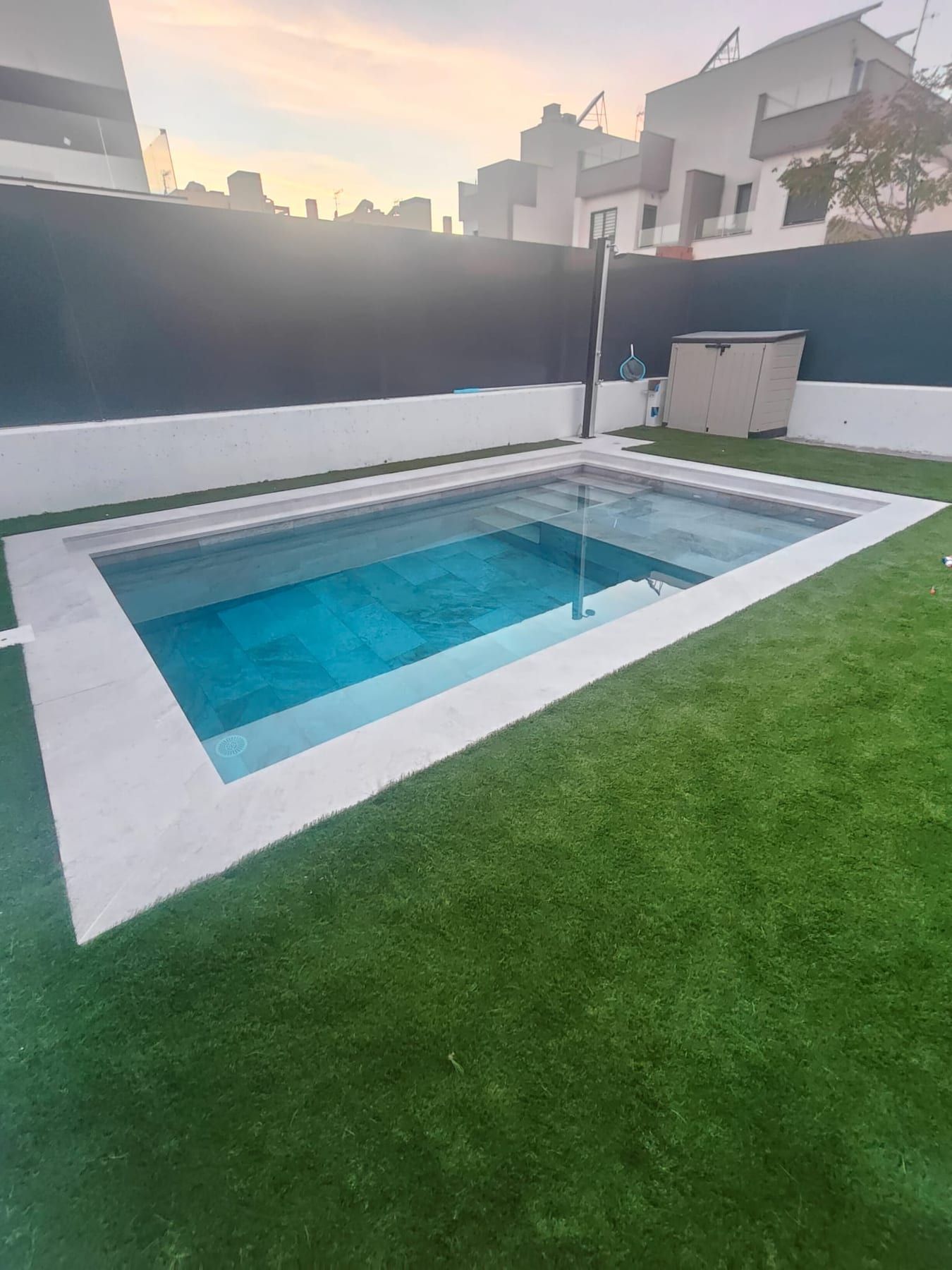 Piscina cuadrada de porcelánico gris con iluminación