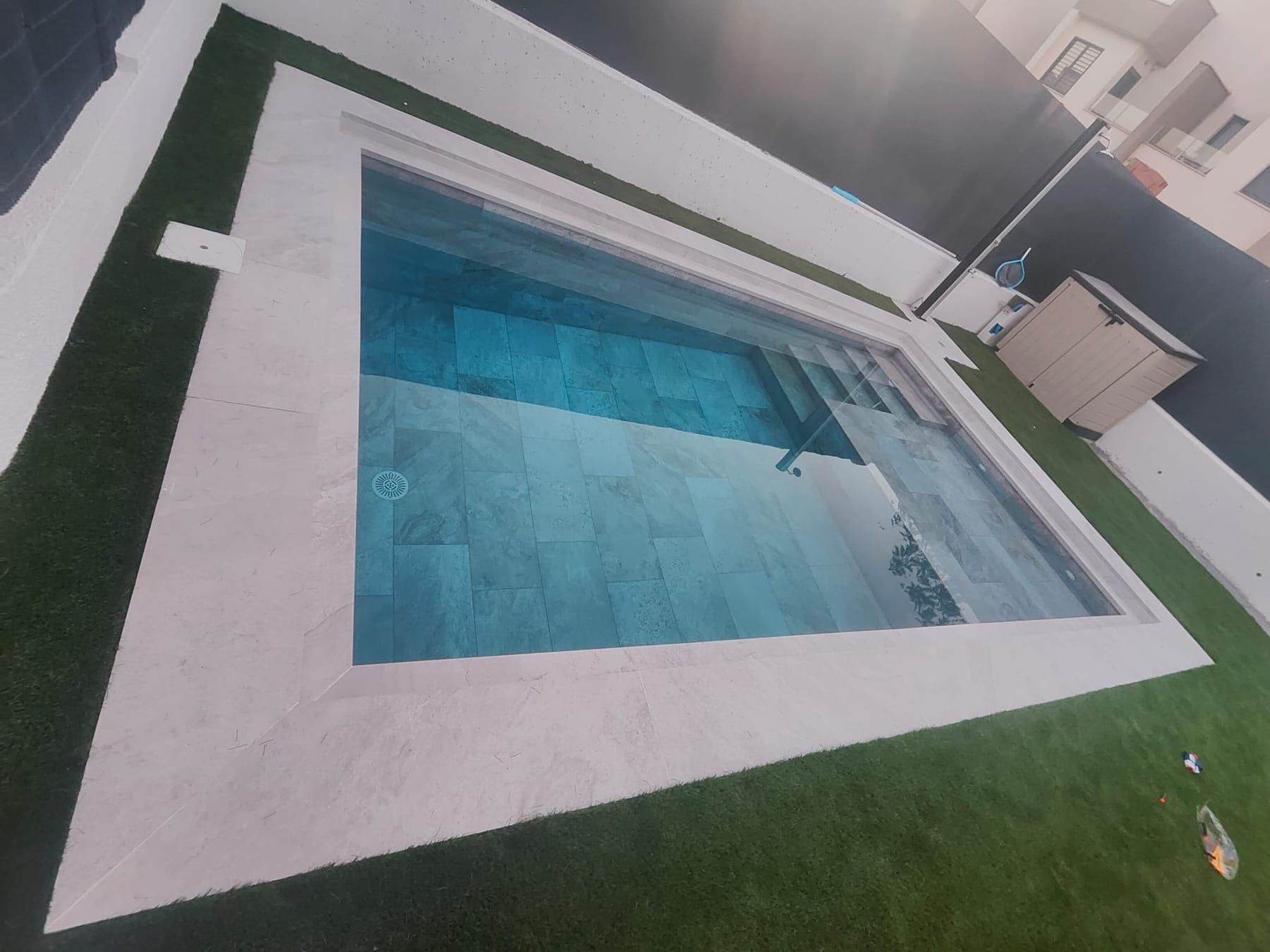 Piscina cuadrada de porcelánico gris con iluminación, vista 2