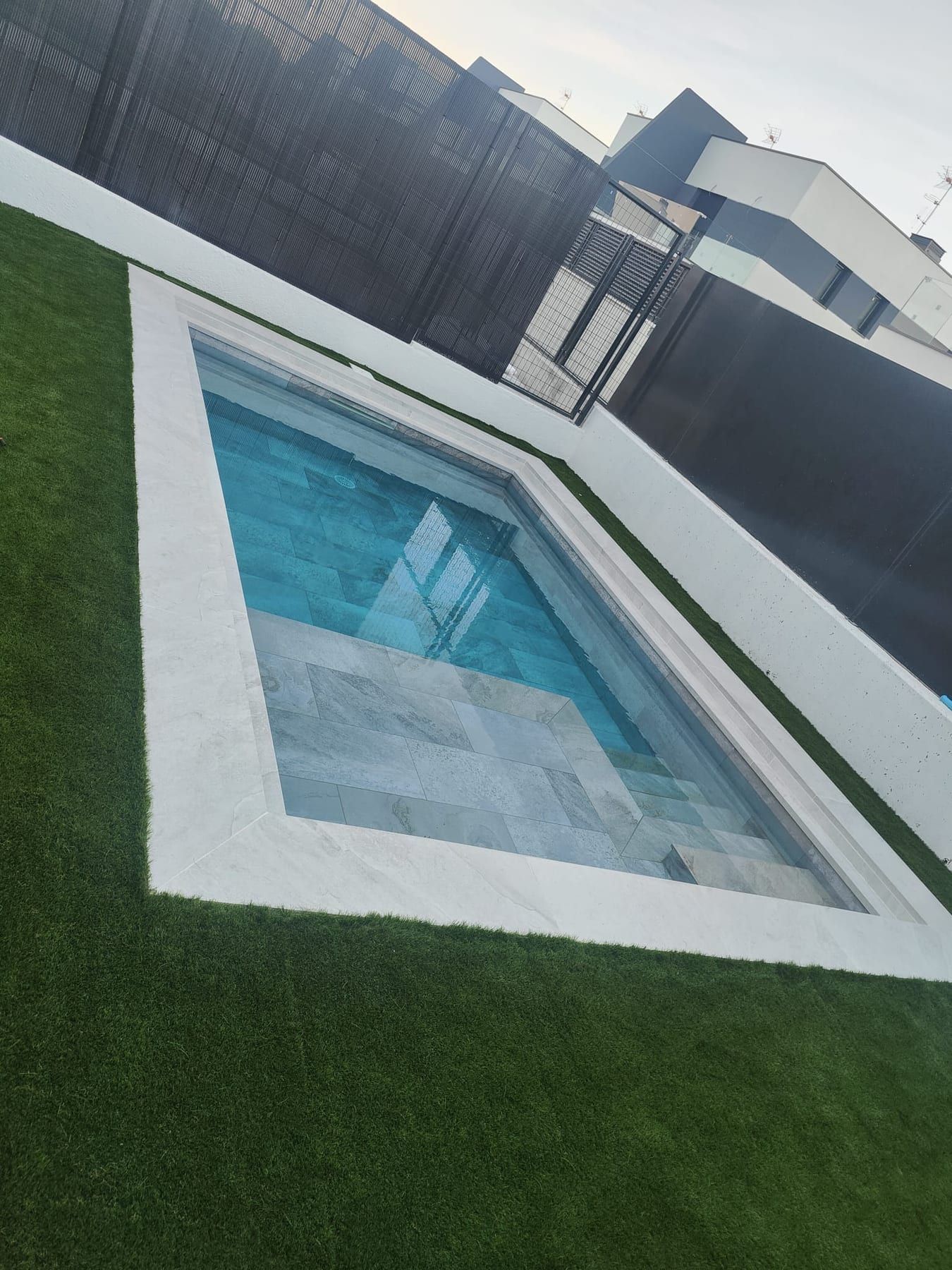Piscina cuadrada de porcelánico gris con iluminación, vista 3