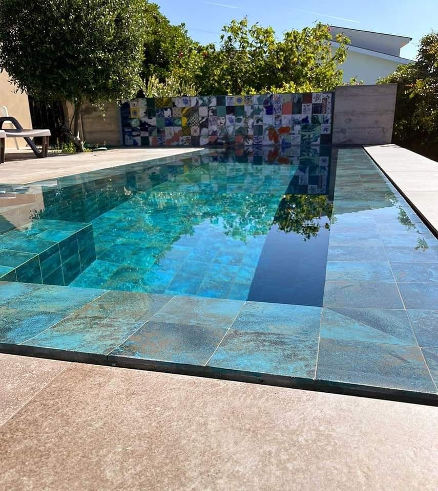 Piscina desbordante con porcelánico verde, vista 3