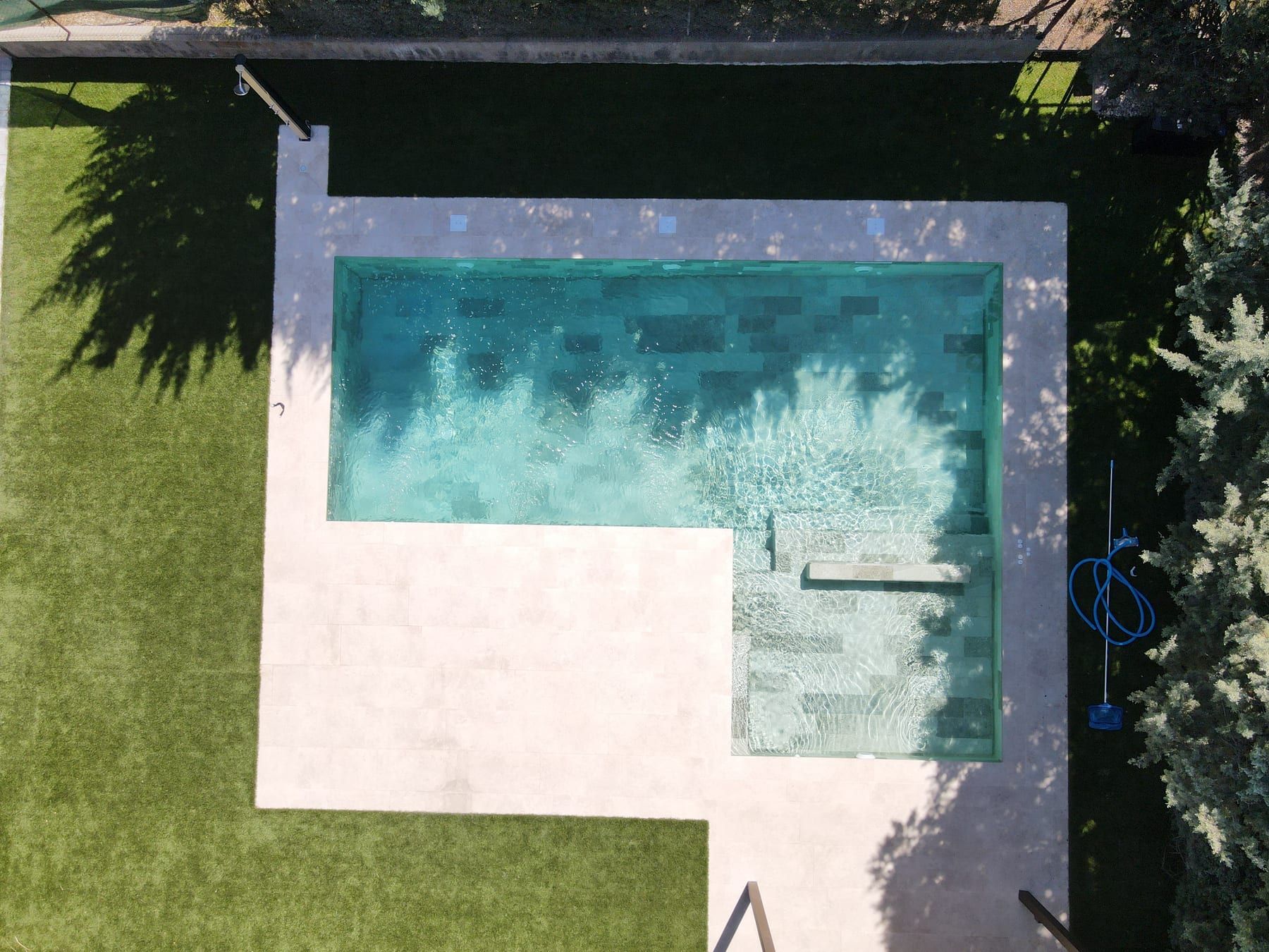Piscina en L vista desde el aire, vista cenital con dron