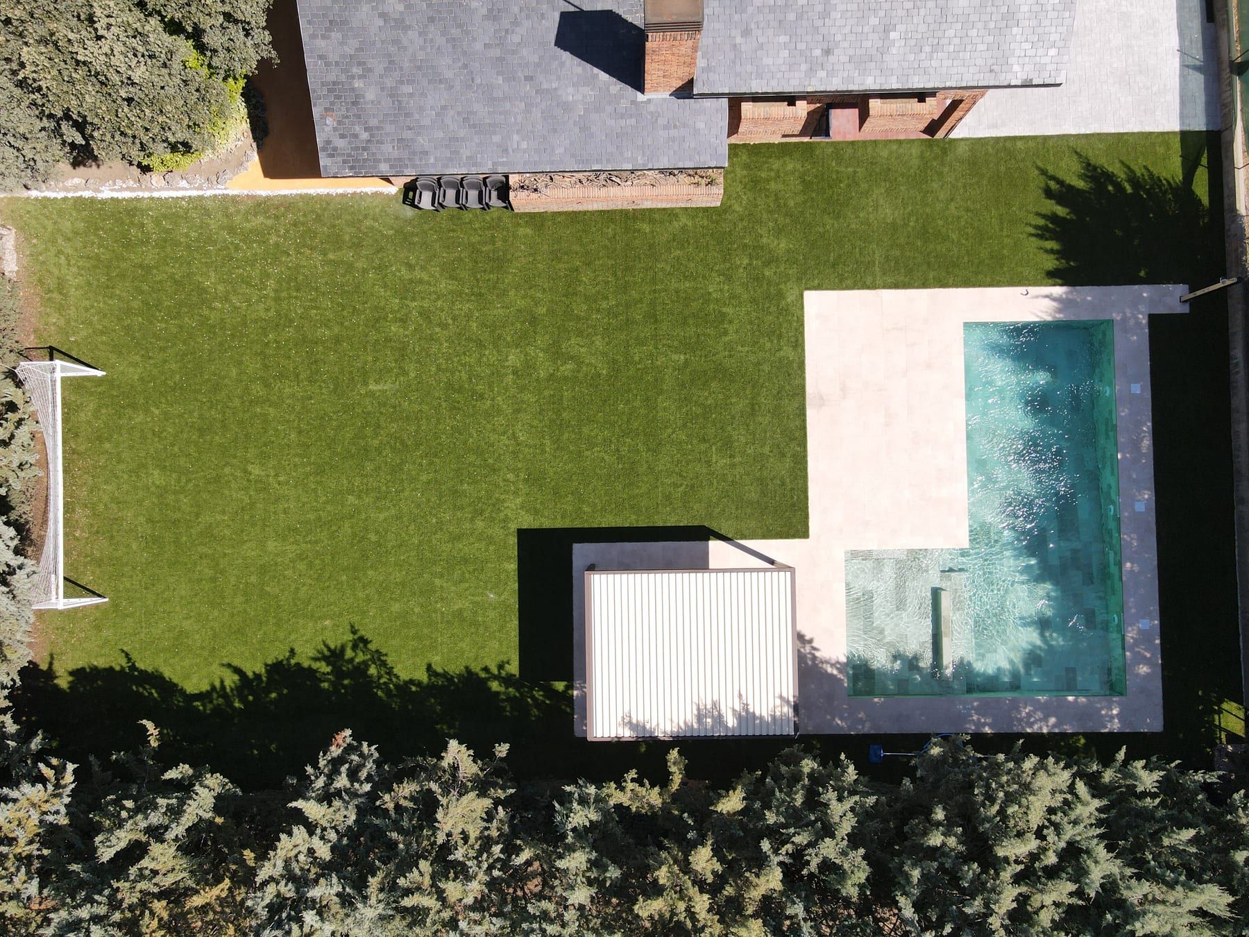 Piscina en L vista desde el aire, vista con dron del jardín