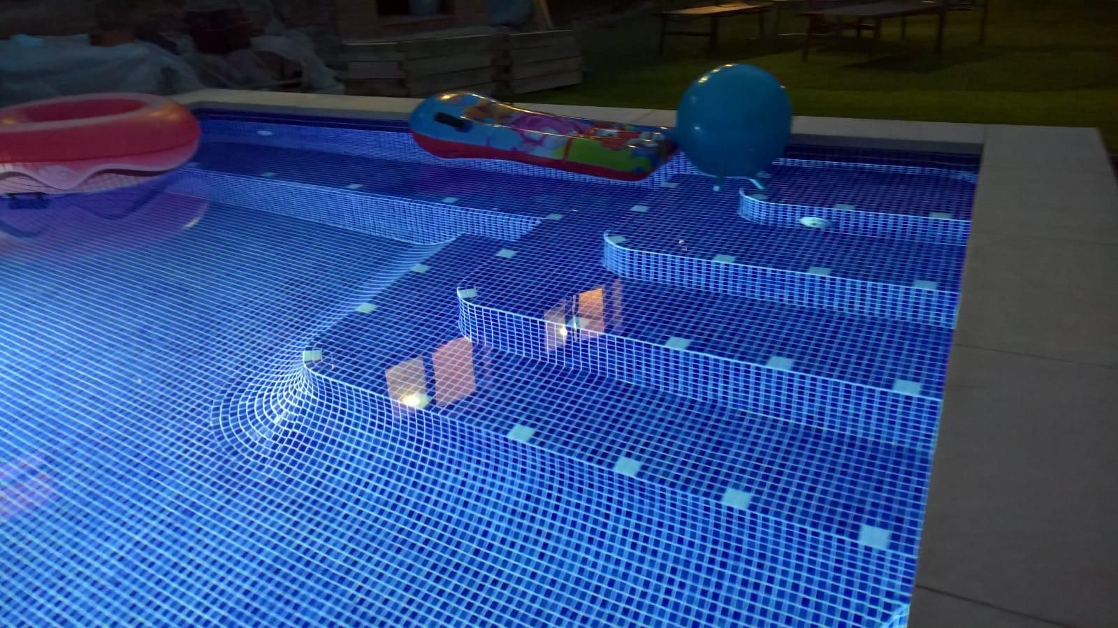 Escalera de obra de ancho completo revestida de gresite azul dentro de la piscina
