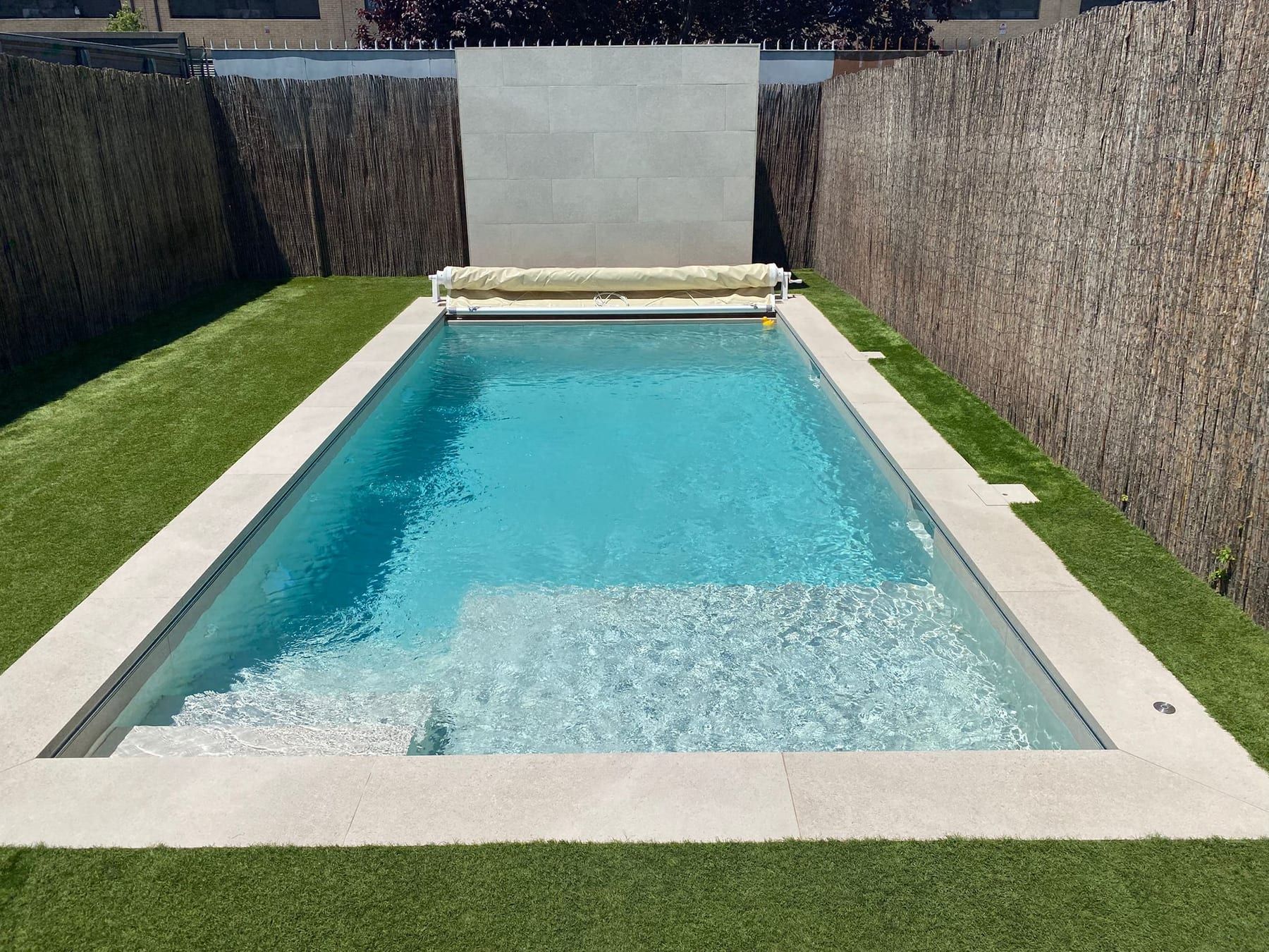 Piscina en jardín estrecho con cubierta de lona e iluminación