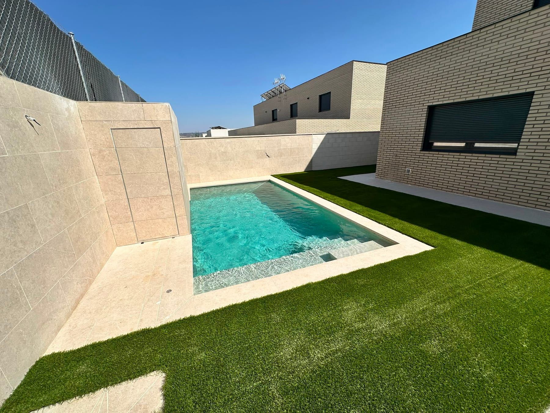 Piscina con muros de porcelánico beige