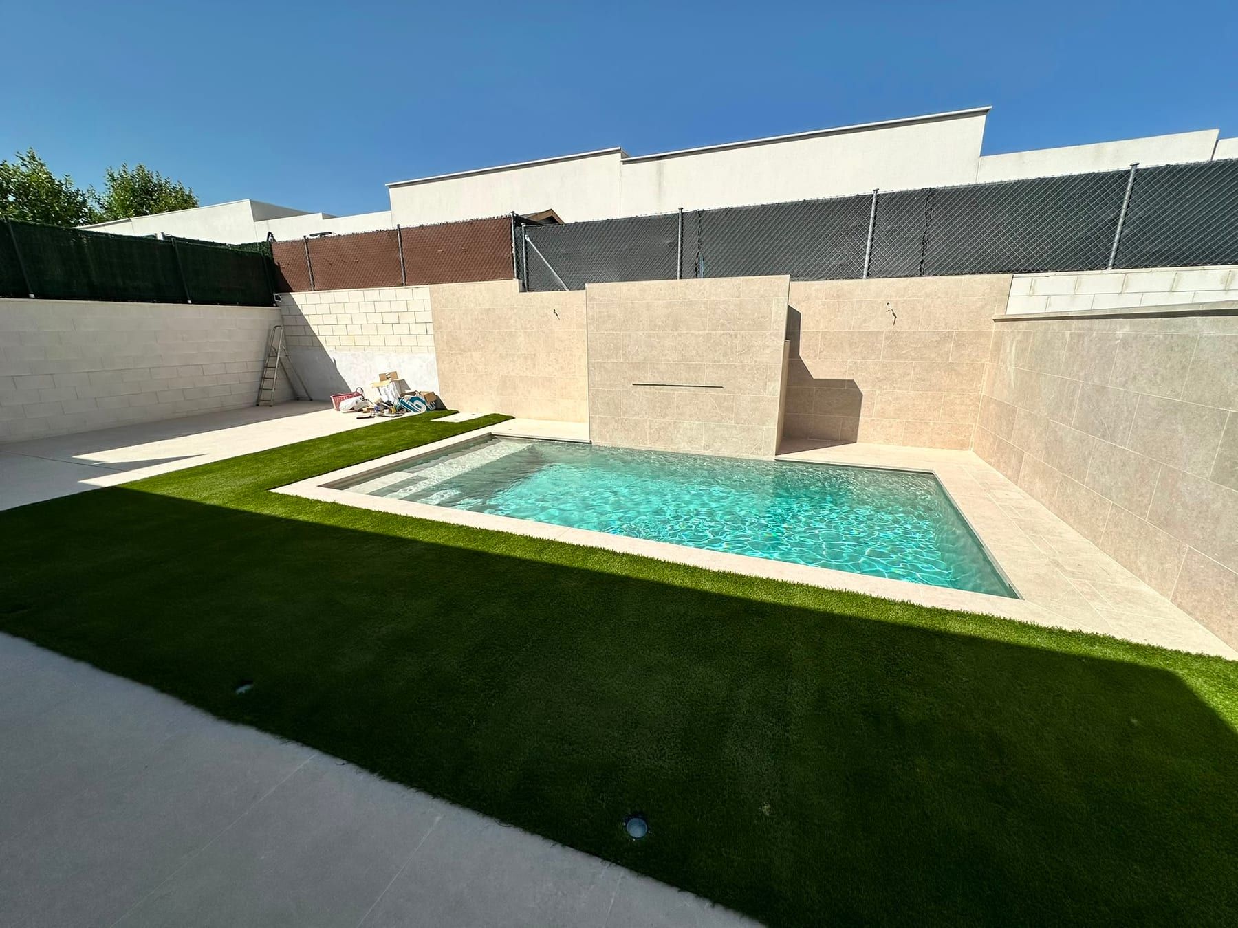 Piscina con muros de porcelánico beige, vista 2